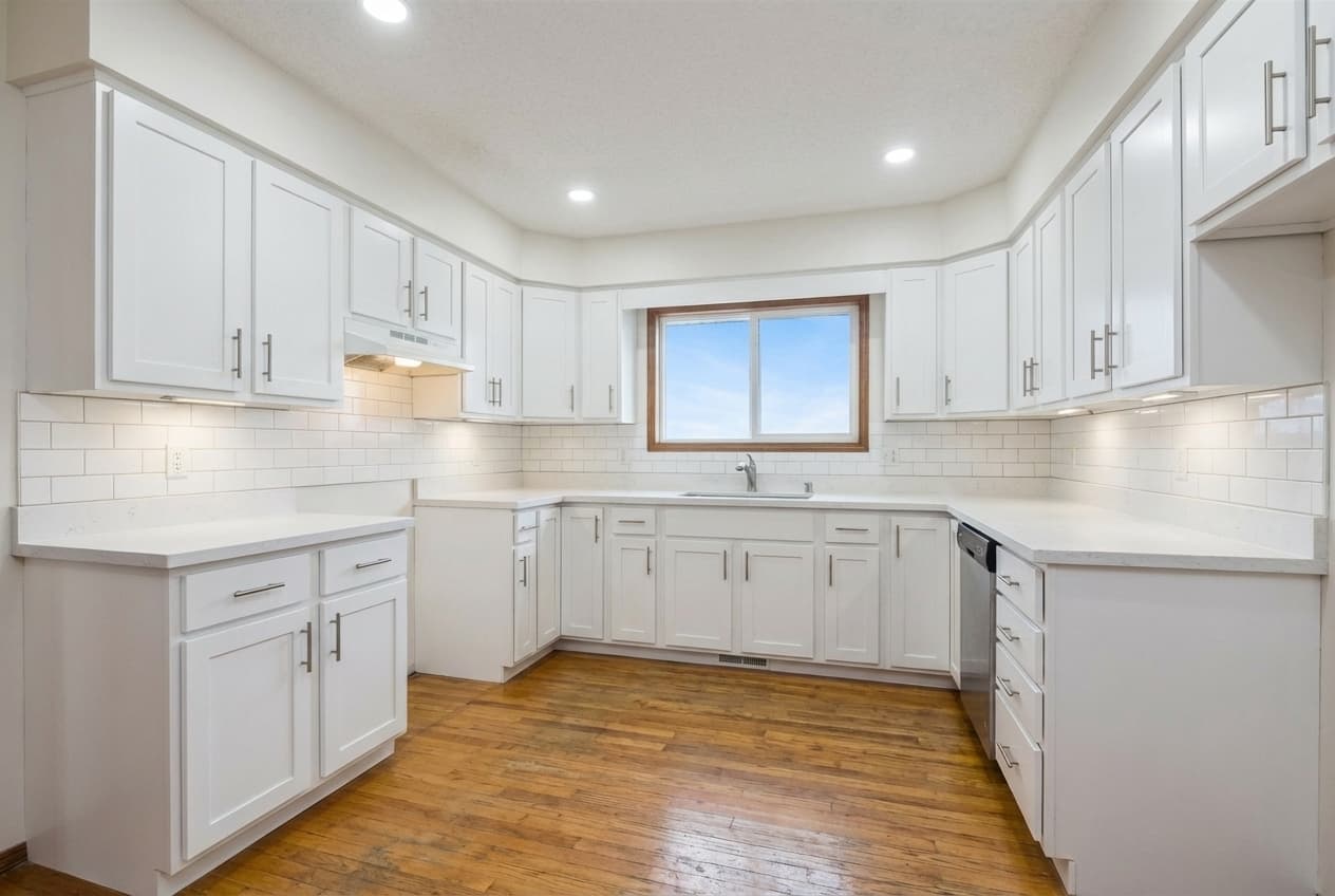 Same kitchen virtually renovated with white cabinets and quartz countertops